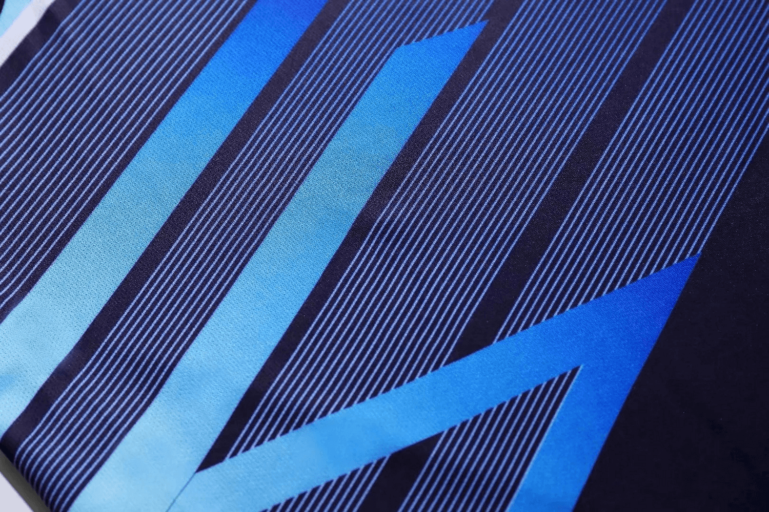 Close-up of vibrant blue geometric pattern on athletic fabric, highlighting sleek design and breathable material of women's sportswear set.